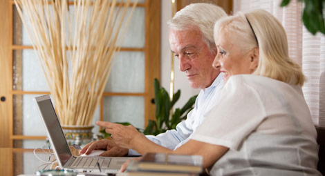 An elderly couple using a laptop